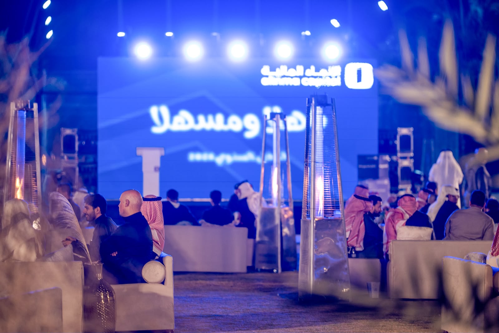 فعالية الإنماء المالية بإشراف عرب هوست — جلسات مسائية وشاشة عرض وإضاءة زرقاء